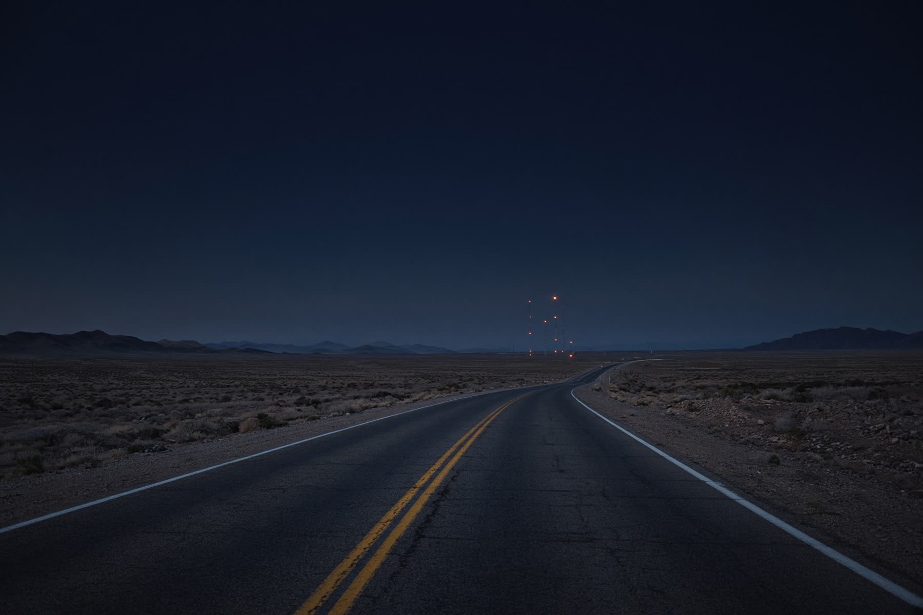 A long, empty highway still from the music catalog — used behind the about-the-music section.
