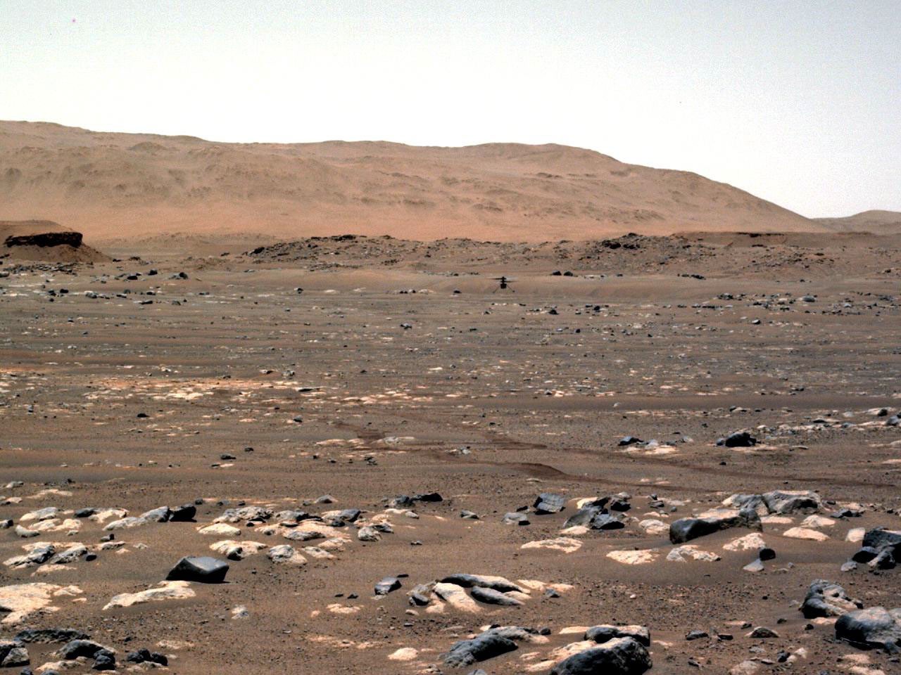 Ingenuity on the sand of Jezero after deployment from Perseverance: four legs, twin carbon rotors, solar panel on top. NASA/JPL-Caltech.