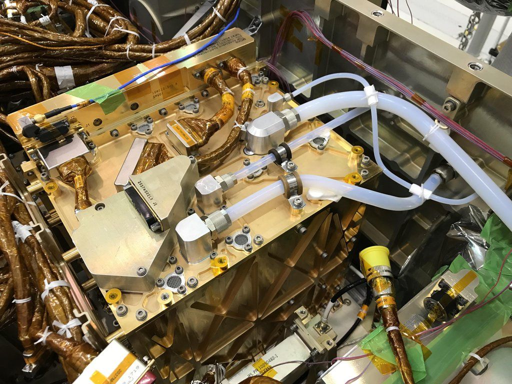 Figure 2 — MOXIE all tucked in. Gold plate. The large white tube takes filtered Martian air. The small tube sends the oxygen through a purity sensor, then vents it.