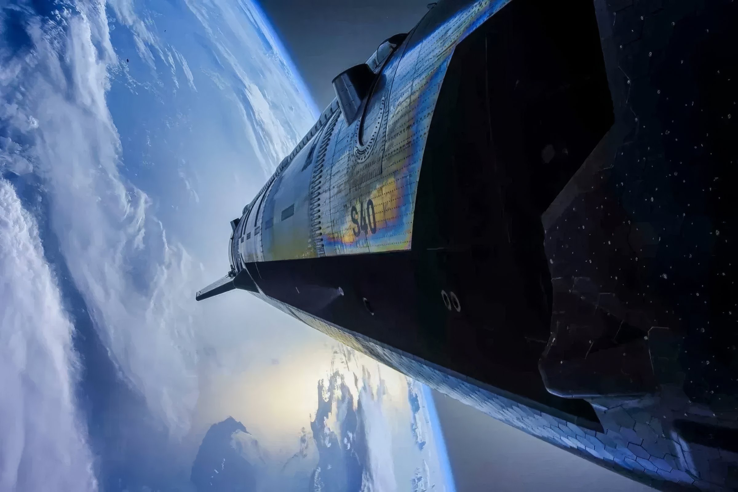 Starship S40 in orbit over a sunlit Earth: heatshield tiles and stainless flank, the ship stretching toward the curved horizon.